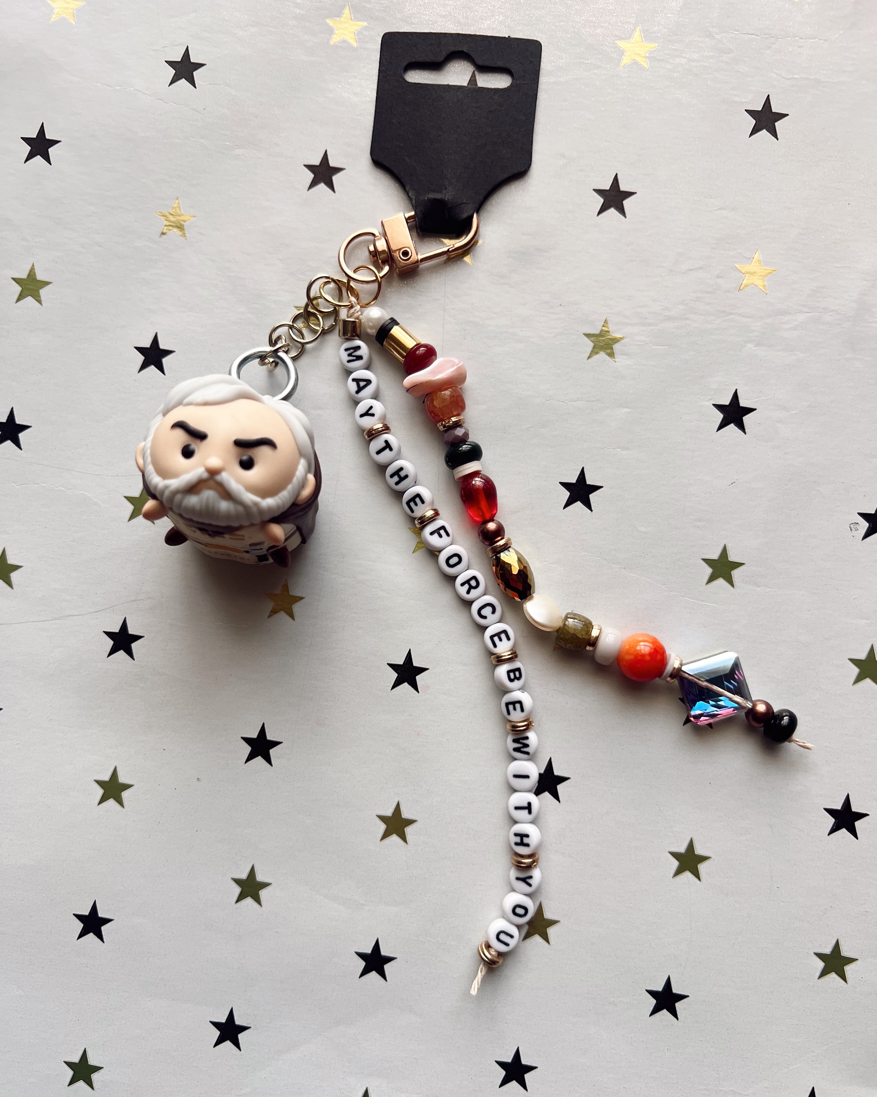 Keychain with character charm and beaded chain on a star-patterned background
