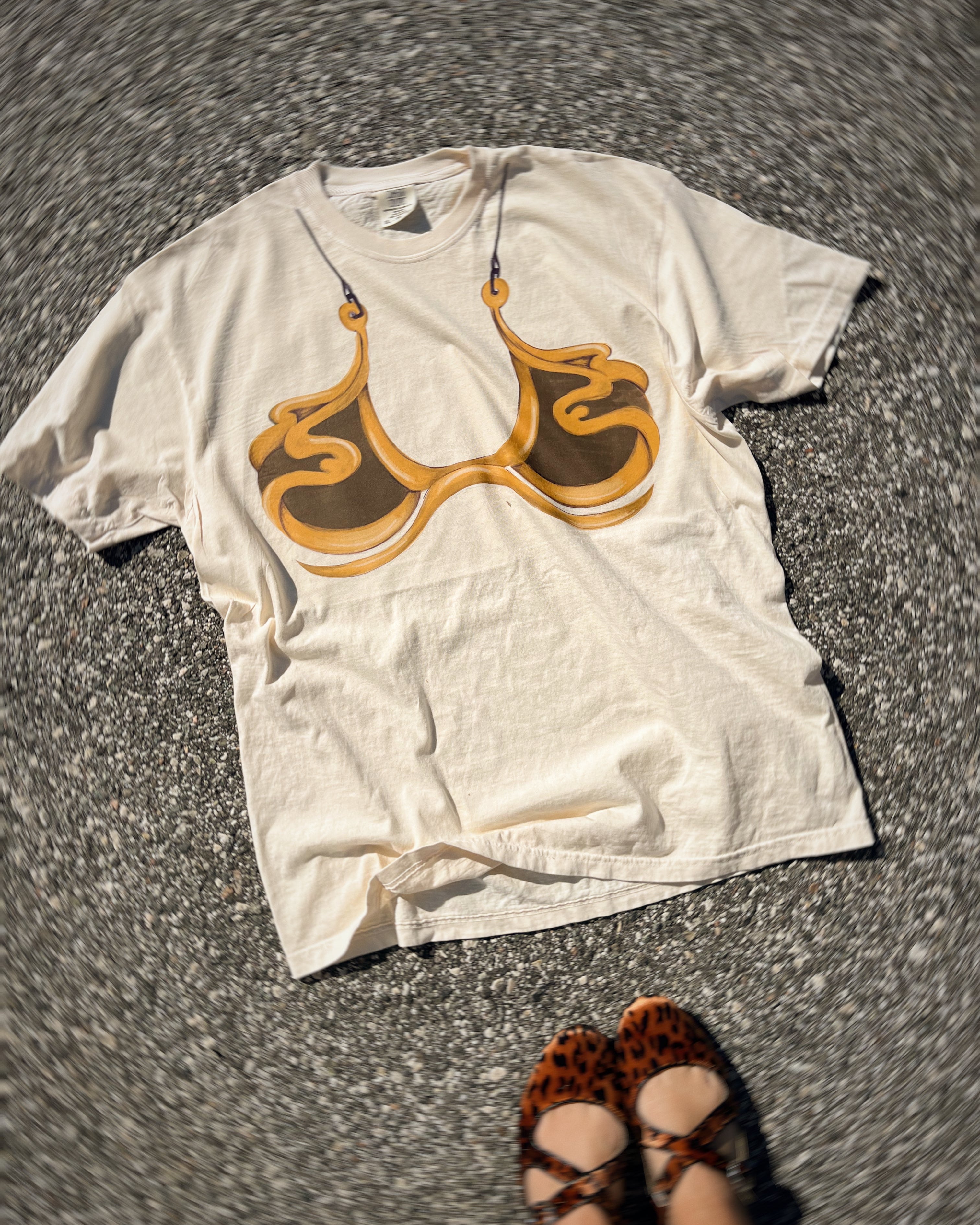 cream tshirt with fake bikini image on front in the style of metal bikini from star wars princess Leia